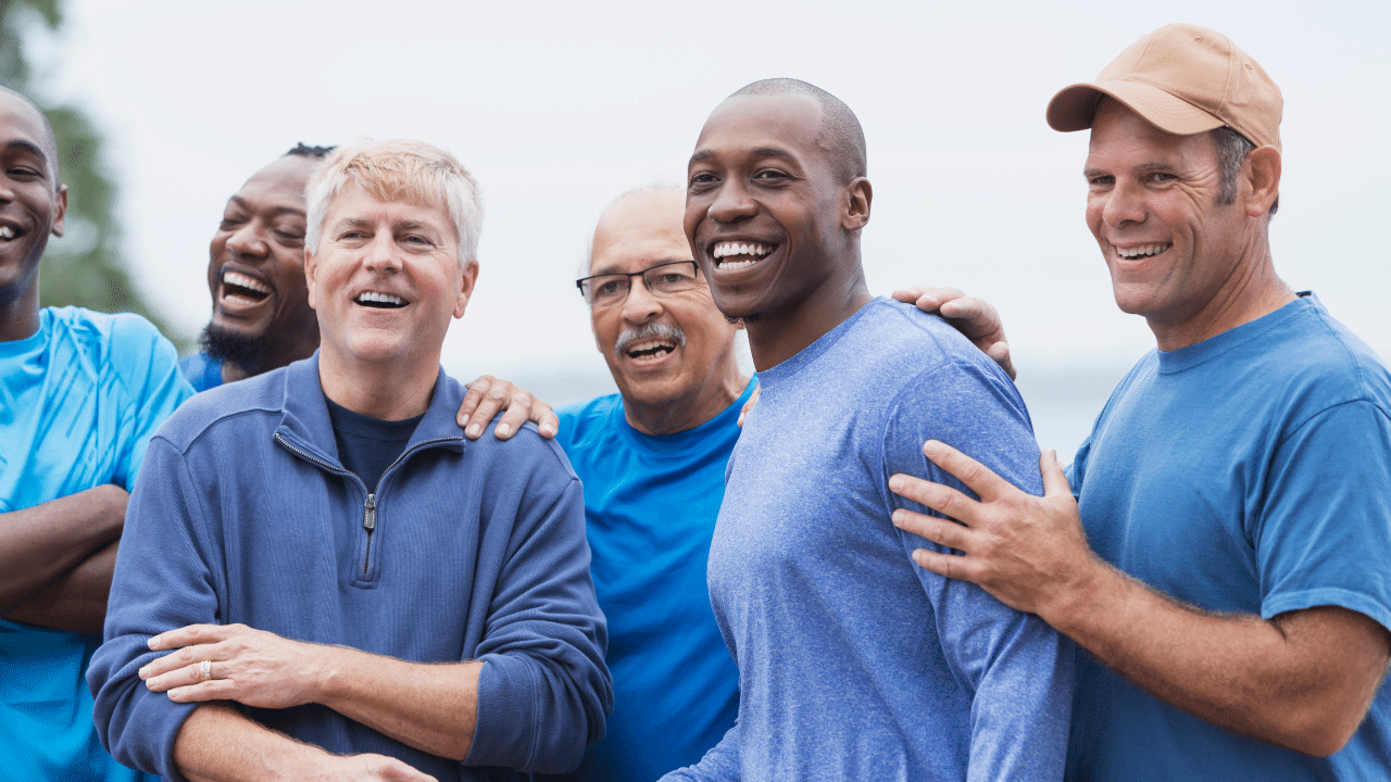 A group of men face a direction behind the camera laughing together